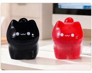 Paire de jolies figurines de chat de dessin animé en résine noire et rouge sur un bureau