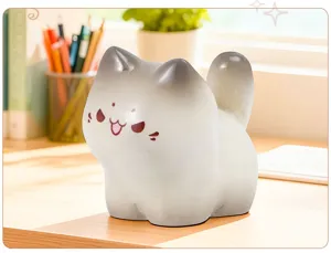 Détail macro d'une figurine de chat en résine avec visage souriant sur un bureau en bois