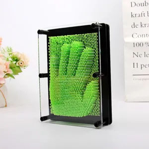 Gros plan d'un tableau d'art 3D à épingles vertes montrant une empreinte de main