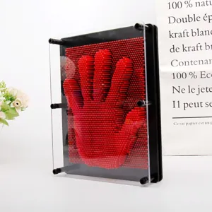 Gros plan d'un jouet pin art 3D rouge avec une empreinte de main