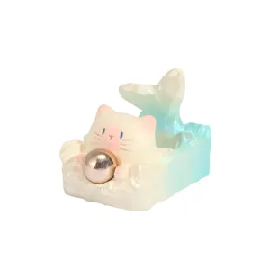 Adorable figurine de chat sirène pastel tenant une boule d'énergie dorée métallique