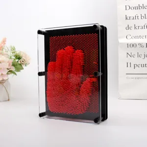 Gros plan d'un jouet à épingles 3D rouge avec une empreinte de main dans un cadre.