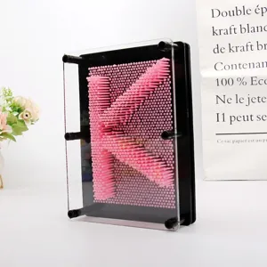 Vue détaillée du jouet d'art 3D à épingles roses formant la lettre K dans un cadre noir
