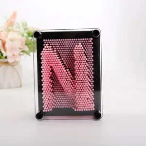 Gros plan de tiges en plastique rose formant la lettre N sur un tableau d'art 3D à picots.