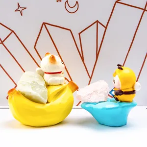 Vue détaillée de deux figurines en résine sur des socles colorés tenant des cristaux bruts