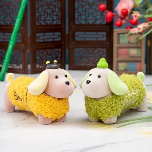 Dettaglio di due statuette di cani floccati temi ape e pera per decorazione da scrivania