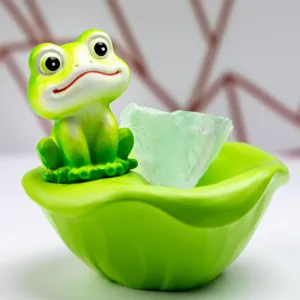 Gros plan d'une figurine de grenouille mignonne en résine sur un nénuphar vert