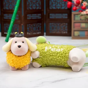 Primo piano di figurine di cuccioli in resina con maglioni ricci colorati