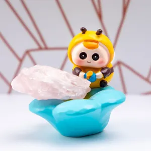 Vue détaillée d'une figurine de bébé abeille en résine avec cristal rose sur socle bleu