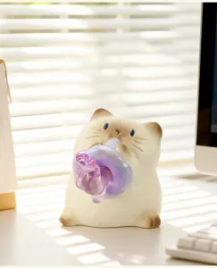 Figurine de chat siamois mignonne tenant une fleur en verre sur un bureau ensoleillé