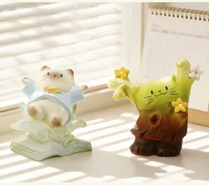Vue détaillée de deux figurines décoratives de chats sur un rebord de fenêtre ensoleillé