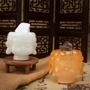 Detailed view of Buddha head resin figurines with raw crystal stones on Zen-style setup