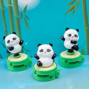 Close-up detail of three cute cartoon panda resin figurines on green bamboo bases