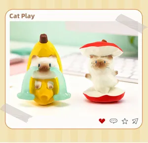 Vue détaillée de deux adorables figurines de chat en résine déguisées en banane et champignon.