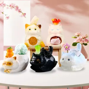 Vue détaillée de figurines de chats en résine tenant des cristaux d'énergie naturelle