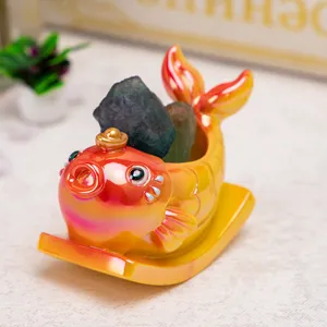Gros plan d'un mignon ornement de poisson à bascule en résine avec une pierre de cristal