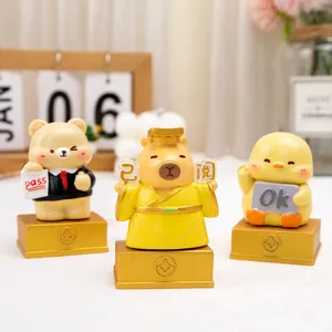 Detailed view of three cute resin cartoon animal figurines on gold bases for office desks