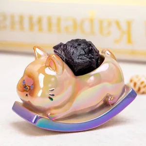 Détail d'une figurine de chat à bascule en résine irisée avec cristal d'améthyste