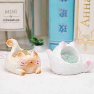Gros plan de figurines de chat en résine avec des pierres de cristal vert décoratives