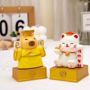 Detailed view of cute cartoon capybara and lucky cat resin figurines on gold bases