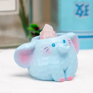 Détail rapproché d'une adorable figurine d'éléphant en résine bleue avec un cristal rose