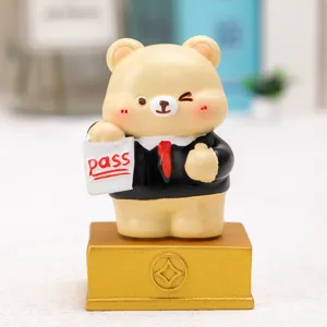 Detailed close-up of a cute cartoon bear figurine in a suit holding a 'pass' sign