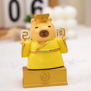 Macro view of a cute capybara resin figurine in a yellow robe for desk decoration