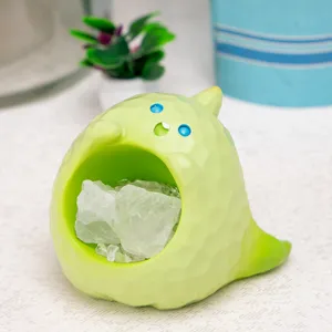 Détail d'une figurine de monstre vert en résine contenant des cristaux blancs naturels