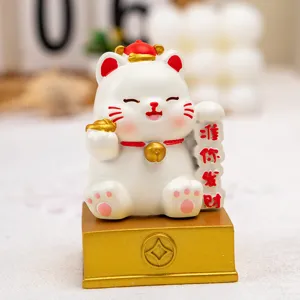 Macro view of a cute resin lucky cat figurine with golden base for desktop decoration.
