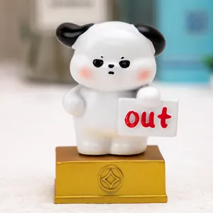 Close-up of cartoon resin dog figurine holding 'out' sign for office desk decor