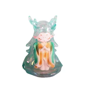 Figurine en résine de créature mythique avec bois verts translucides en pose de prière