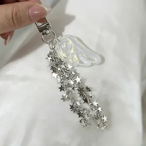 Macro shot of a shimmering resin angel wing and metallic star chain bag charm detail