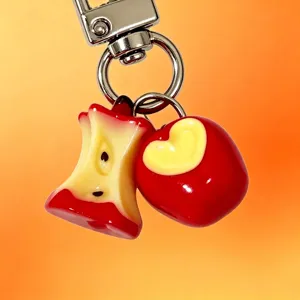 Close-up detail of cute red bitten apple and apple core charms on metal keychain
