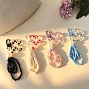 Detail of colorful butterfly beaded phone charms with seed beads and pearls in four colors.