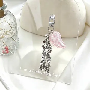 Close-up detail of a pink glittery angel wing keychain with dangling silver star chains
