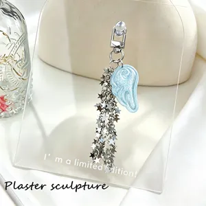 Detail view of a glittery blue angel wing and silver star chain keychain pendant