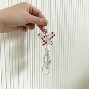 Detailed close-up of a butterfly charm with elegant pearls and white bead tassels
