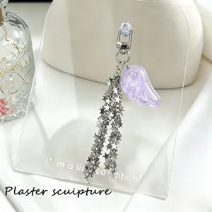 Close-up detail of purple glitter angel wing and cascading silver star metal chains