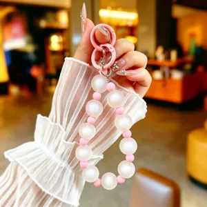 Frosted white and pink beaded phone strap shown in detail being held by a hand