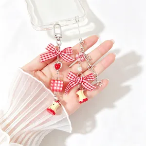 Detailed view of sweet red gingham bow phone charm with realistic bitten apple core