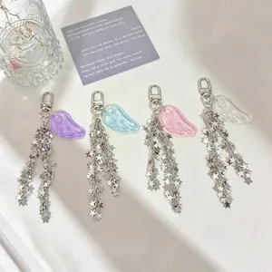 Close-up of cute angel wing keychains featuring long silver star chains in four colors.