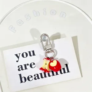 Detail of a cute bitten apple keychain charm with realistic fruit design for bag or phone
