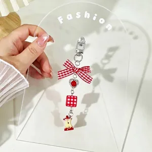 Close-up of a handmade red checkered bowknot keychain with a cute bitten apple charm