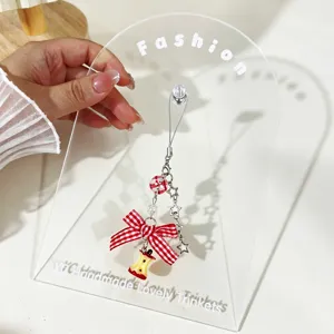 Close-up of a cute bitten apple phone charm with a red gingham bow and stars.
