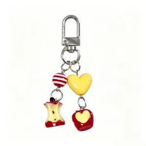 Cute bitten apple and heart charm keychain with glossy finish on white background