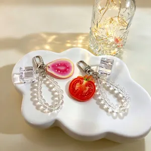 Close-up of fruit slice keychains with clear crystal beads and acrylic ice cubes