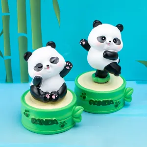 Detailed view of two cute panda resin spinning figurines on decorative green bamboo bases.