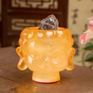 Translucent amber resin Buddha head figurine with raw crystal stone top for zen decor.