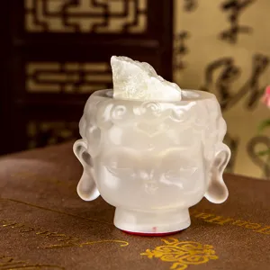 Translucent milky white resin Buddha head figurine with a natural raw crystal stone