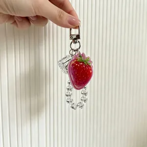 Detail view of strawberry keychain with clear crystal beads and ice cube charm